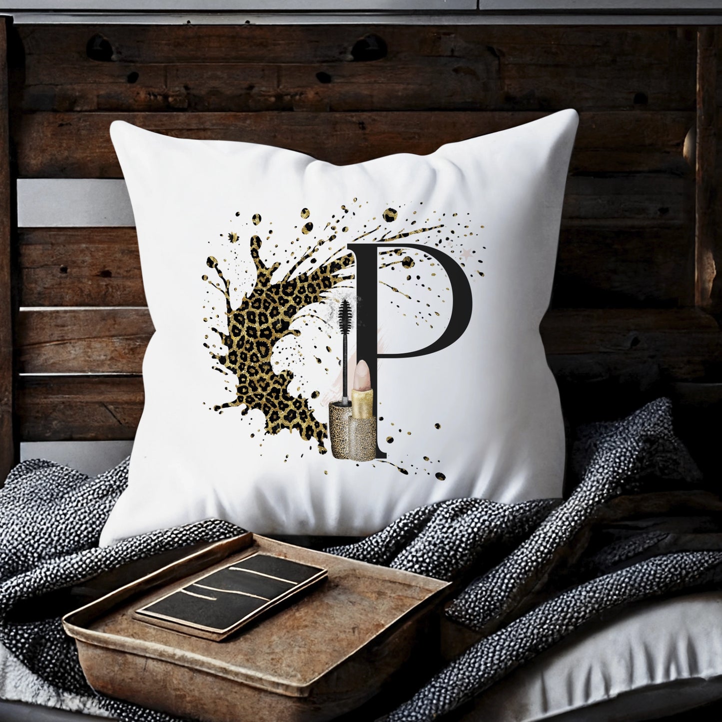 Cushion with a leopard print background splash and an initial letter P with a lipstick and mascara