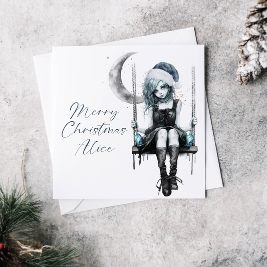 Personalised Christmas card featuring a goth girl wearing a Christmas hat and sitting on a swing