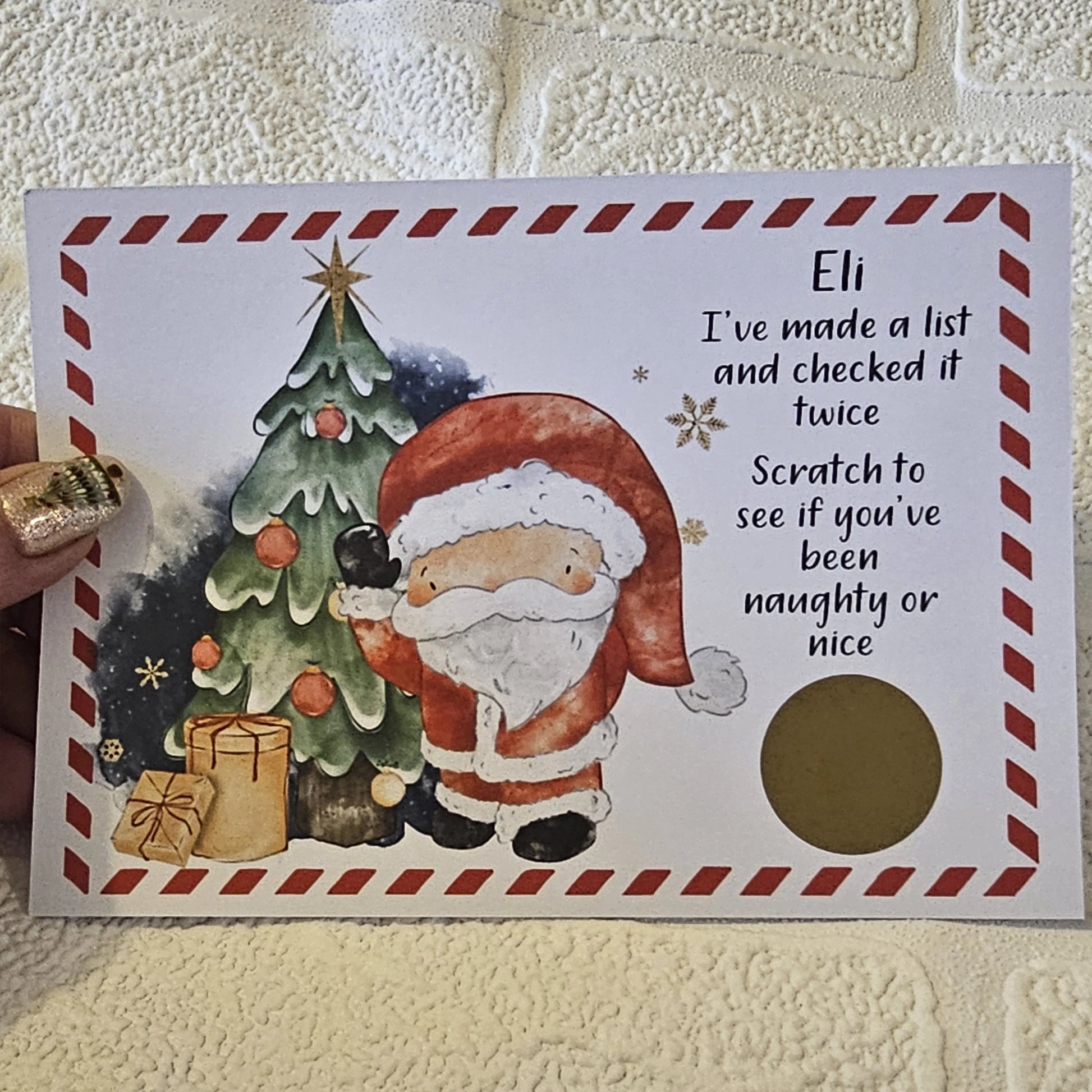 A card with an image of Santa Claus next to a Christmas tree with the text 'I've made a list and checked it twice. Scratch to see if you've been naughty or nice' This is personalised and has a gold scratch off sticker