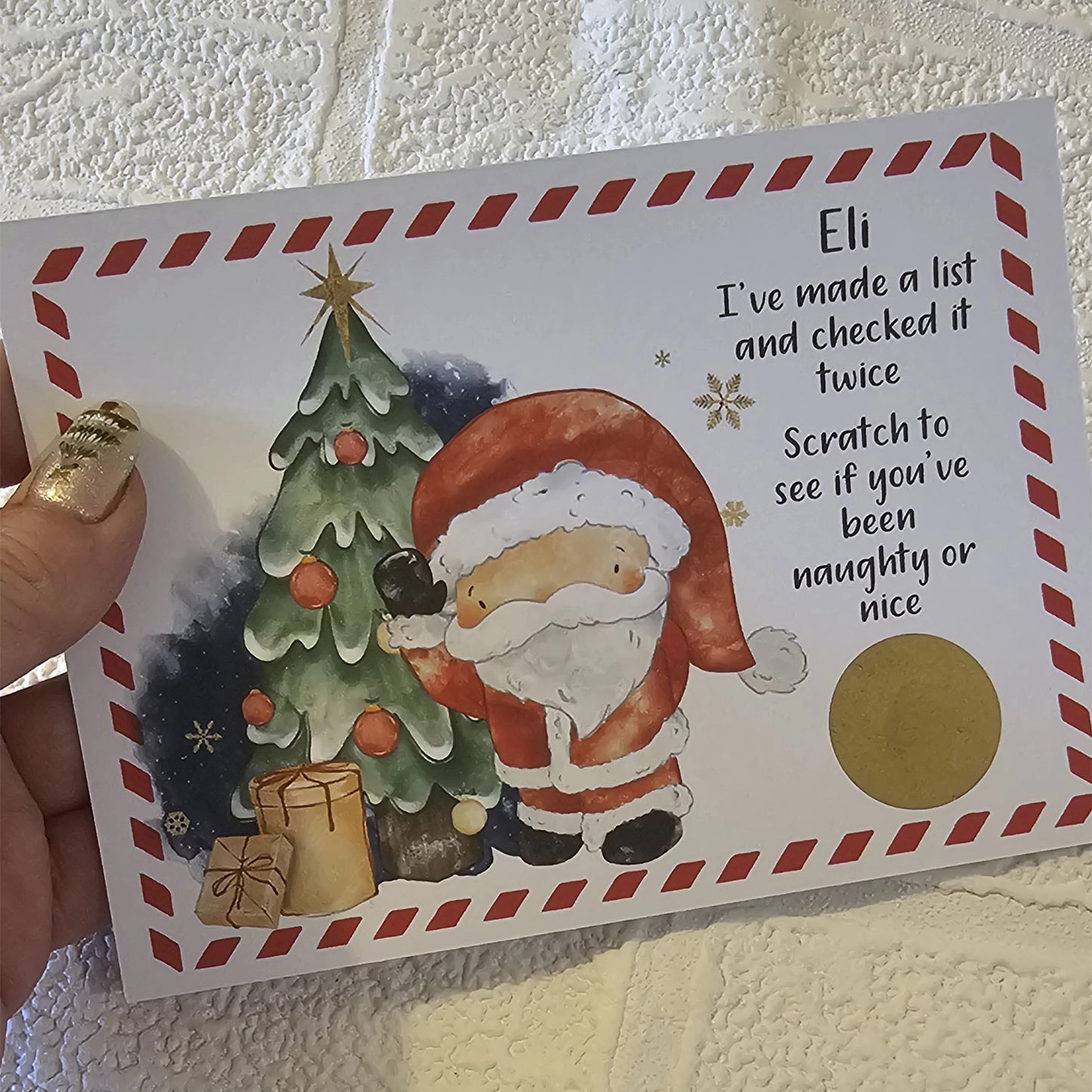 A card with an image of Santa Claus next to a Christmas tree with the text 'I've made a list and checked it twice. Scratch to see if you've been naughty or nice' This is personalised and has a gold scratch off sticker