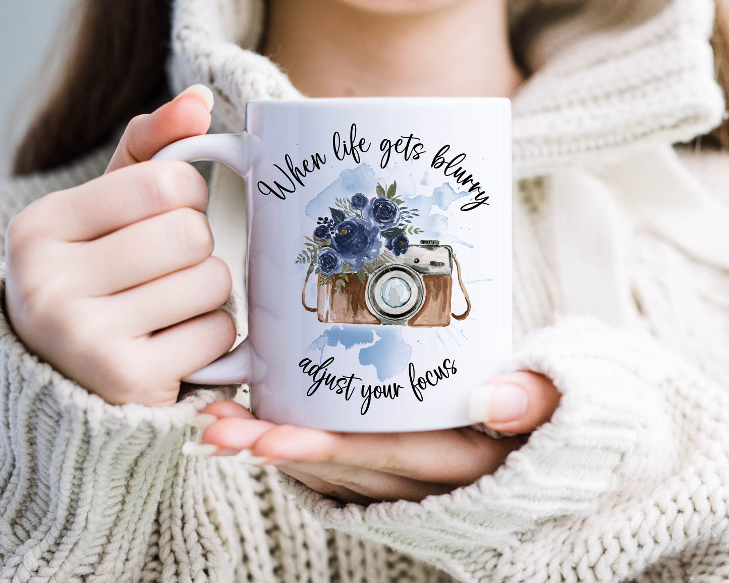 Retro camera design with blue flowers on a blue watercolour splash with the text 'When life gets blurry, adjust your focus'