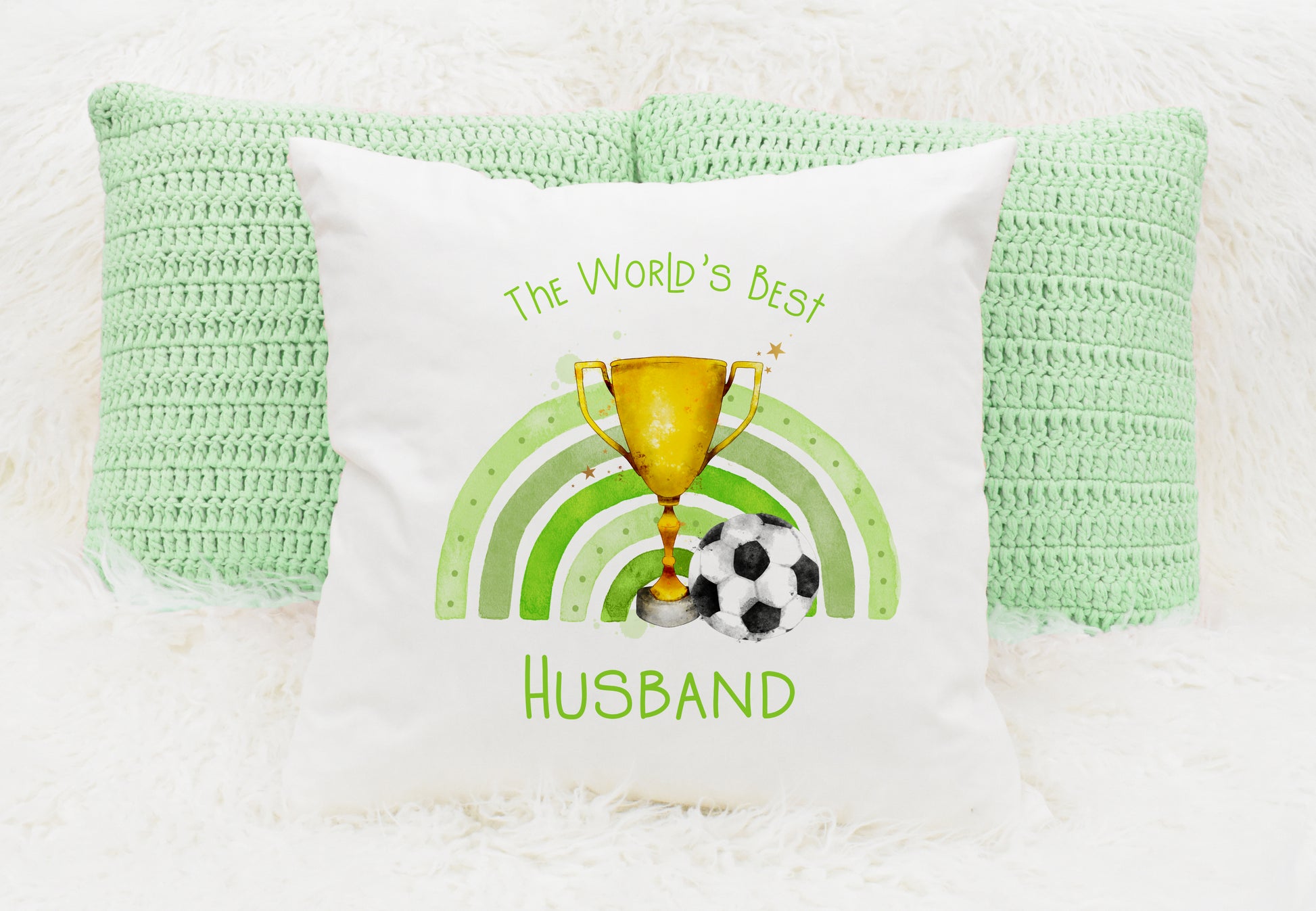 Square cushion featuring a rainbow in green, a trophy and a football. Text reads 'The World's Best' and can be personalised
