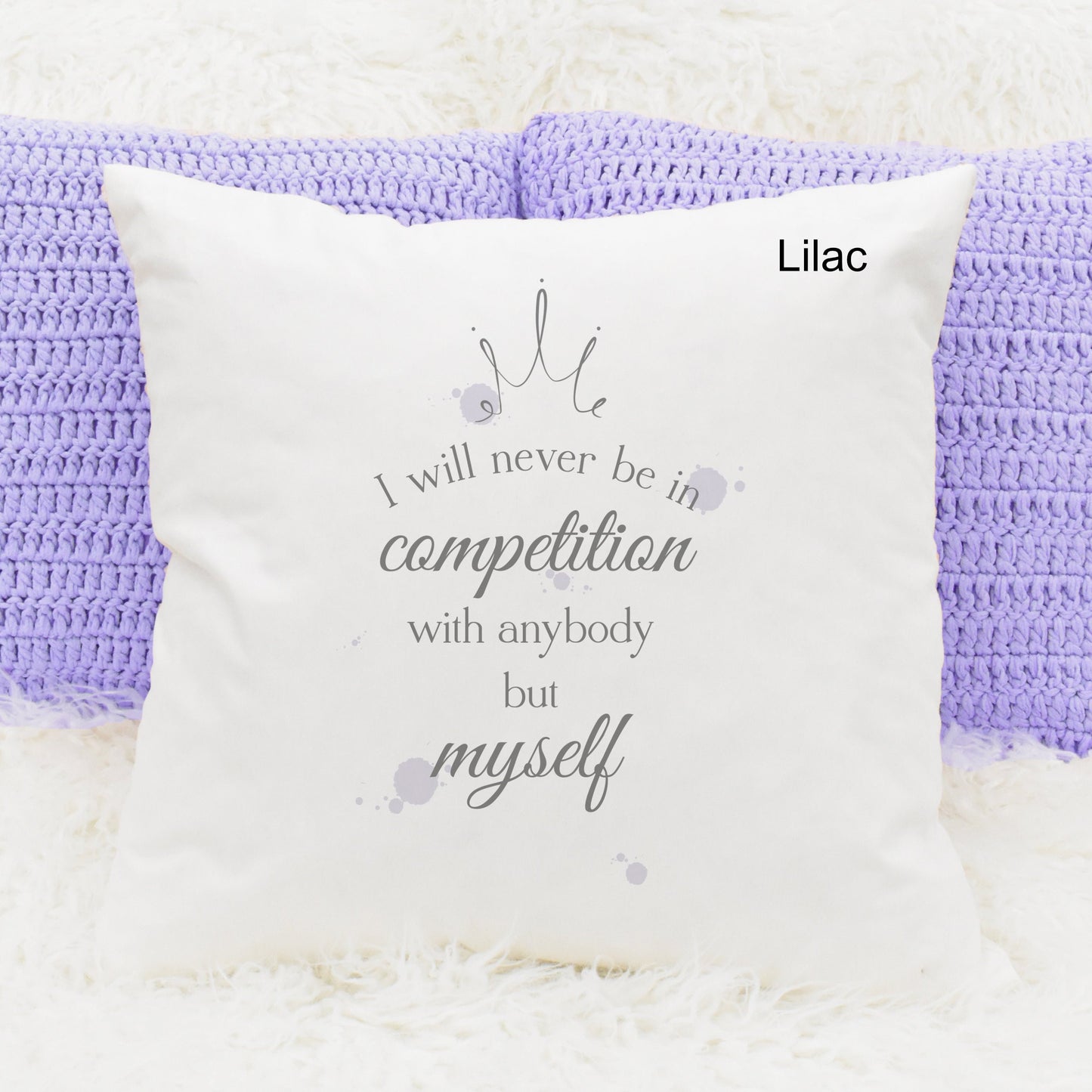 Square cushion featuring lilac watercolour splodges and a crown with the text 'I will never be in competition with anybody but myself'