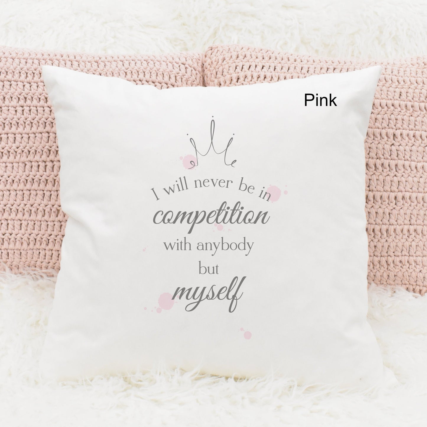 Square cushion featuring pink watercolour splodges and a crown with the text 'I will never be in competition with anybody but myself'