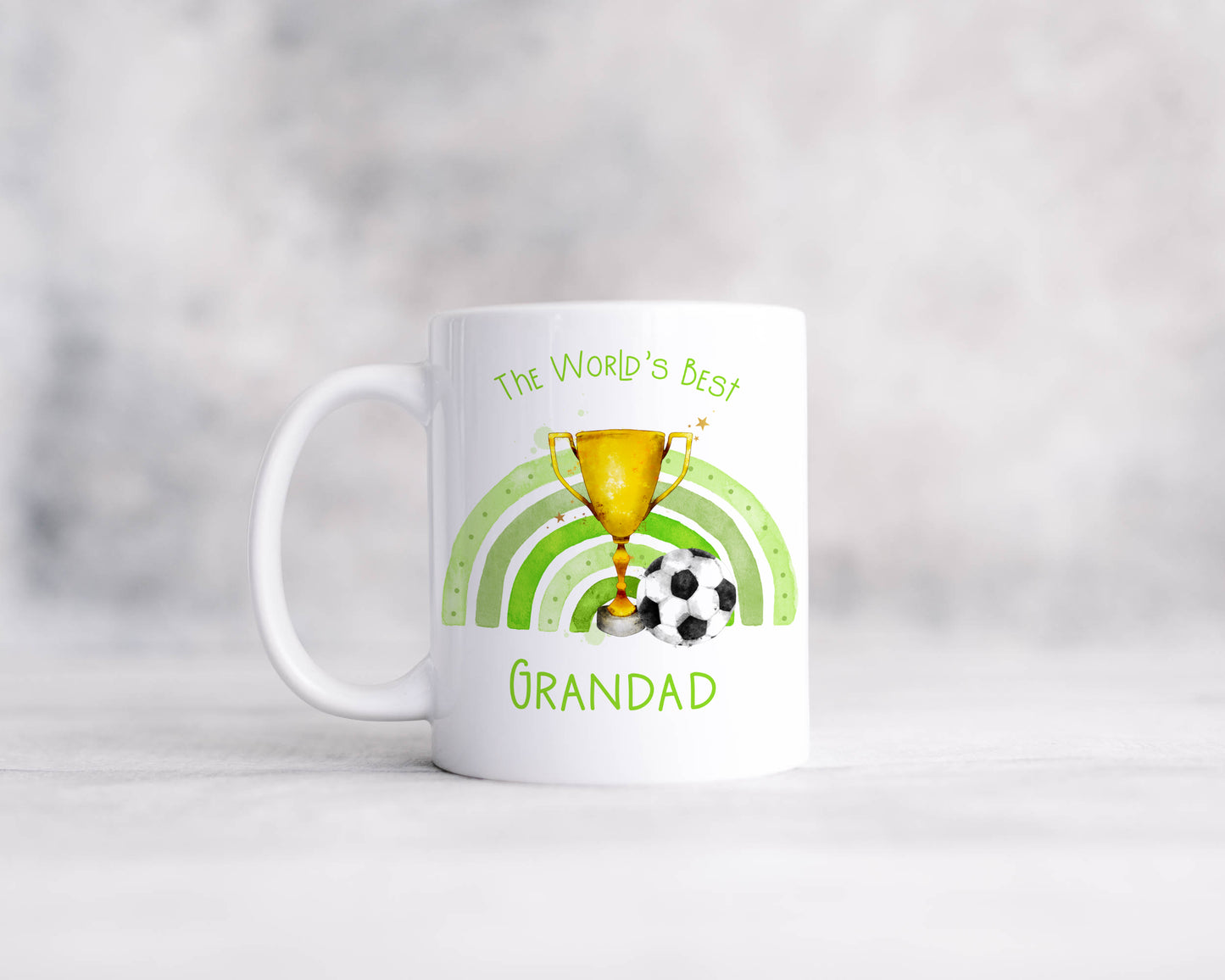 Ceramic mug featuring a trophy, football and green rainbow. The text reads 'The World's best' and can be personalised