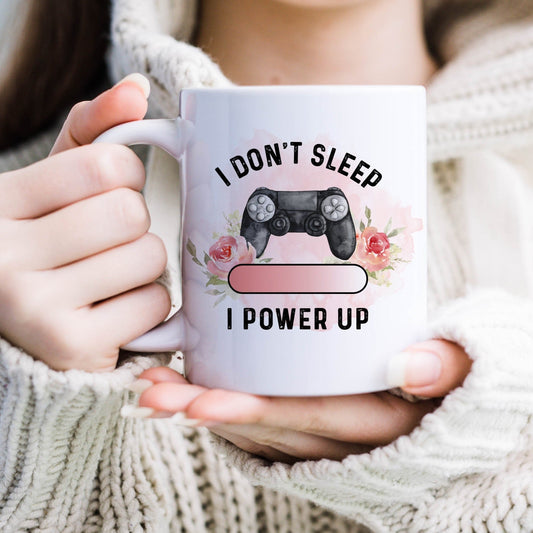 Ceramic mug with the picture of a gaming controller and flowers and the text 'I don't sleep, I power up'