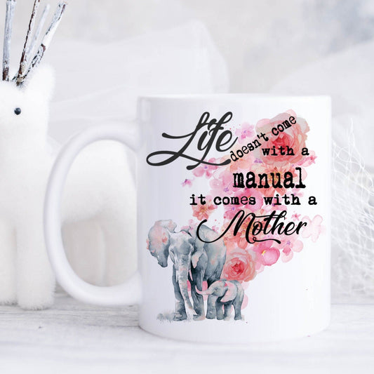Ceramic mug featuring an elephant and baby elephant design with the text saying 'life doesn't come with a manual it comes with a Mother'