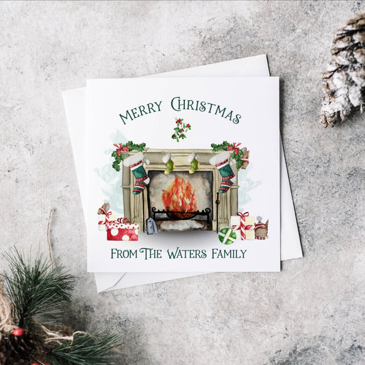 Personalised Christmas greeting card featuring a traditional fireplace, green and red stockings, cute mice and gifts