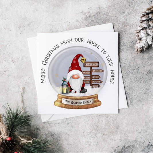 Christmas greeting card featuring Santa with a signpost and a lantern within a snowglobe, text can be personalised