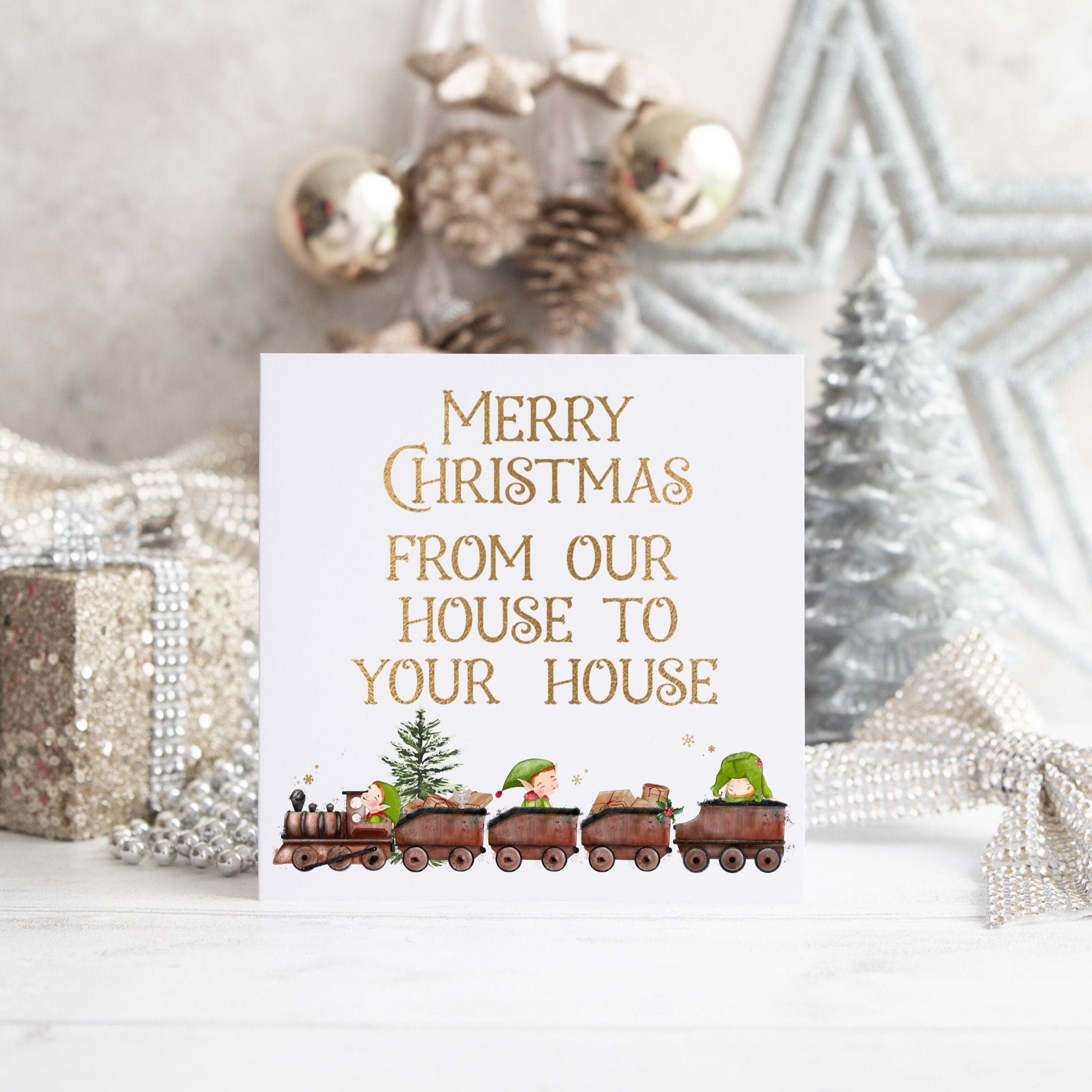 Christmas card with an elf train design and text reading 'Merry Christmas from our house to your house'