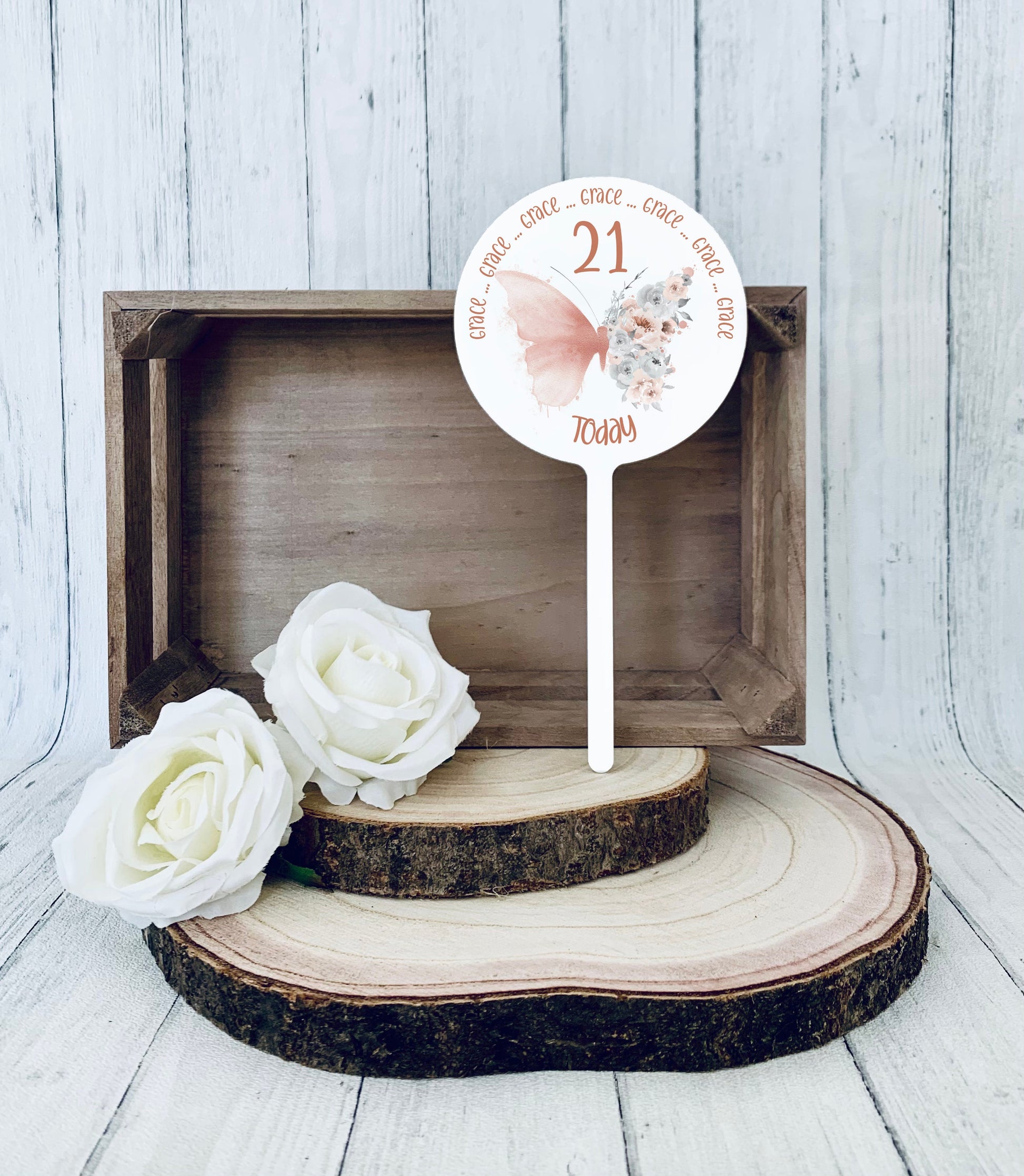 Acrylic round cake topper featuring  a rose gold floral butterfly with personalised birthday text