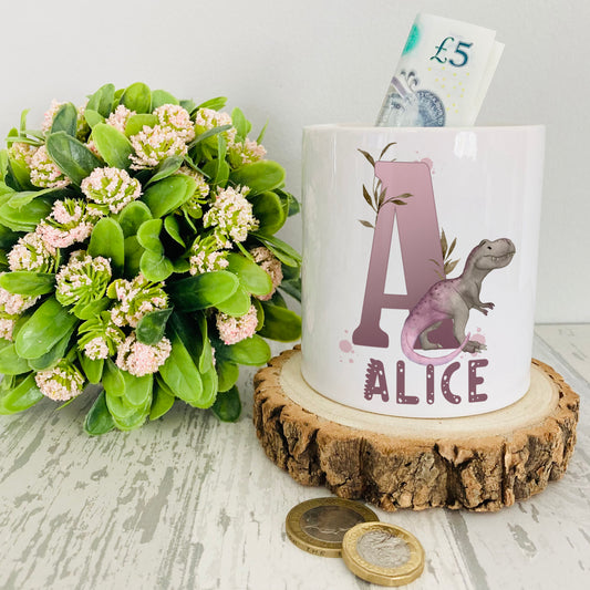 Personalised ceramic money box with a lilac dinosaur alphabet design