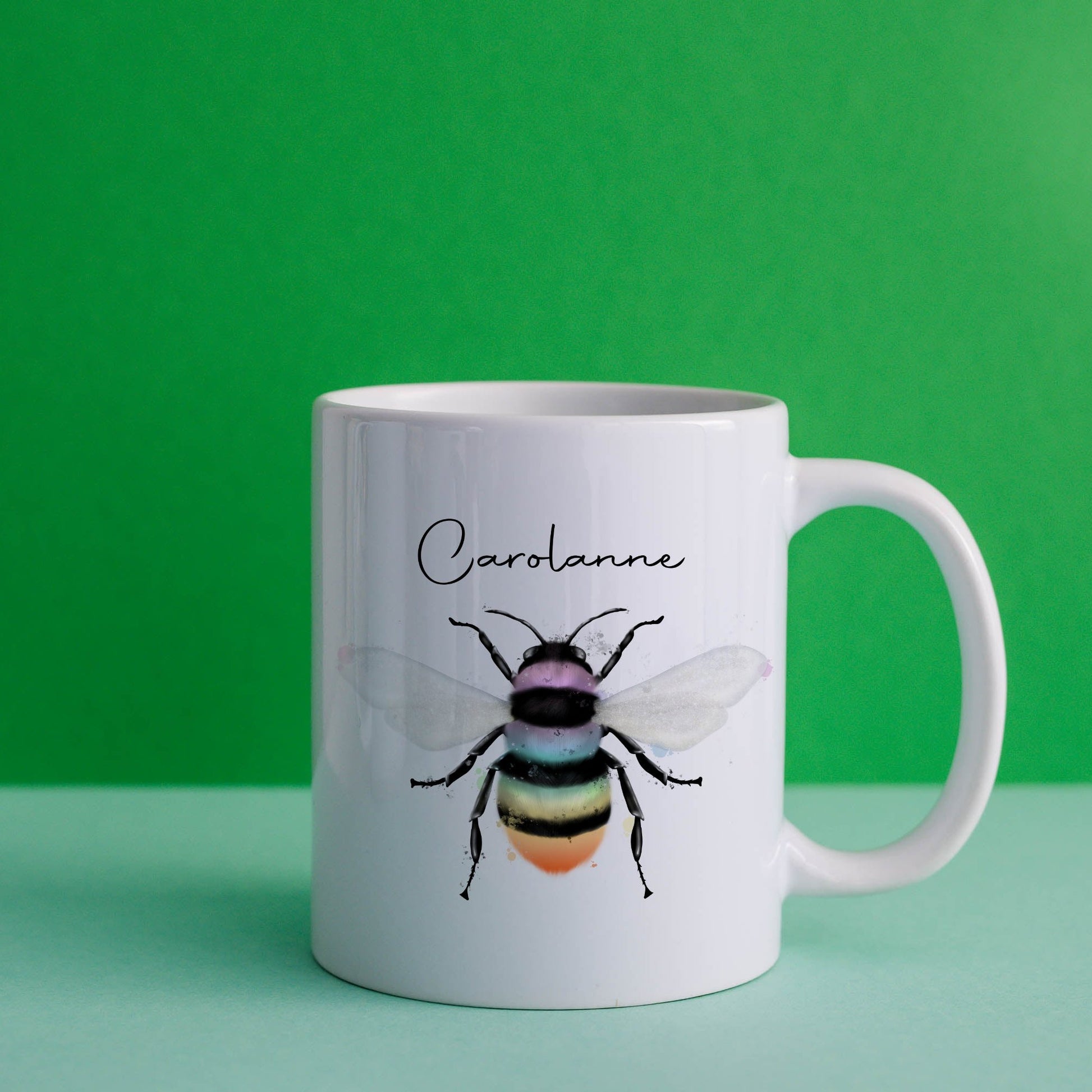 Ceramic mug with the design of a rainbow coloured bumble bee and can be personalised