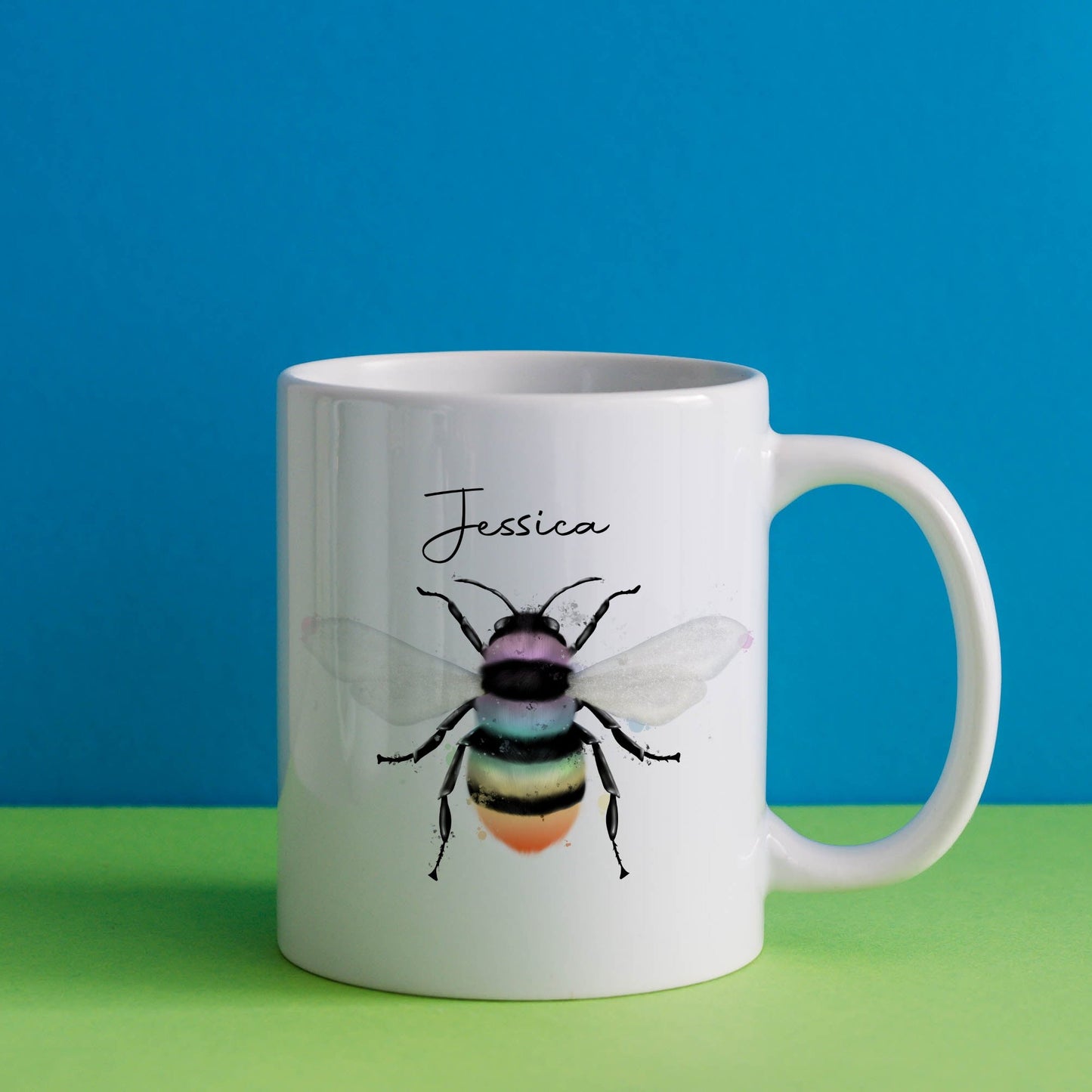 Ceramic mug with the design of a rainbow coloured bumble bee and can be personalised