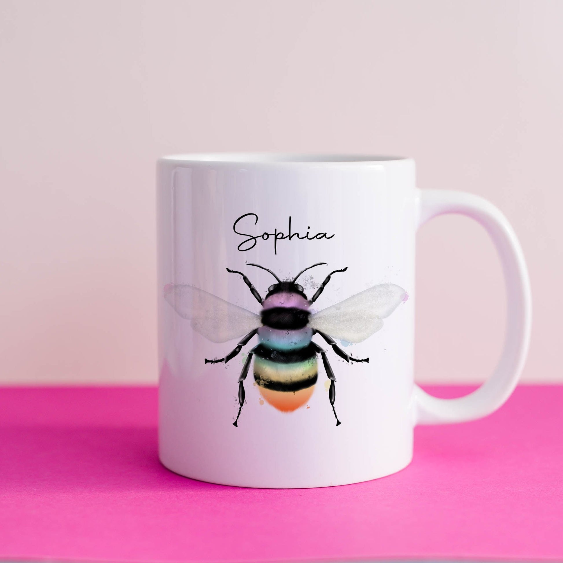 Ceramic mug with the design of a rainbow coloured bumble bee and can be personalised