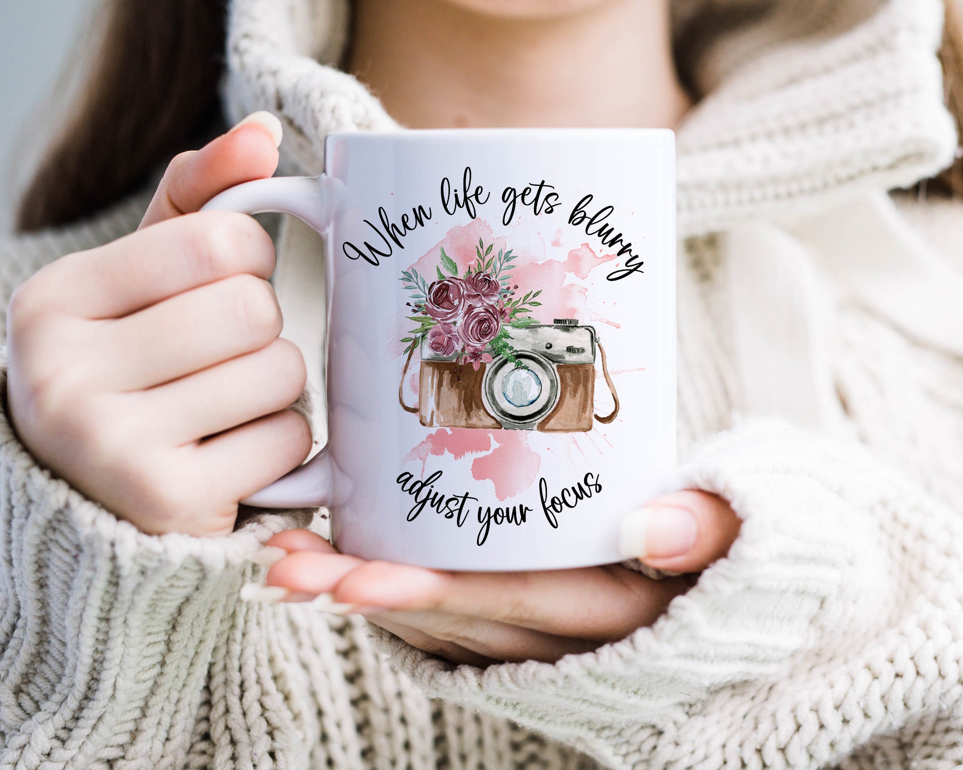 Retro camera design with pink flowers on a pink watercolour splash with the text 'When life gets blurry, adjust your focus'
