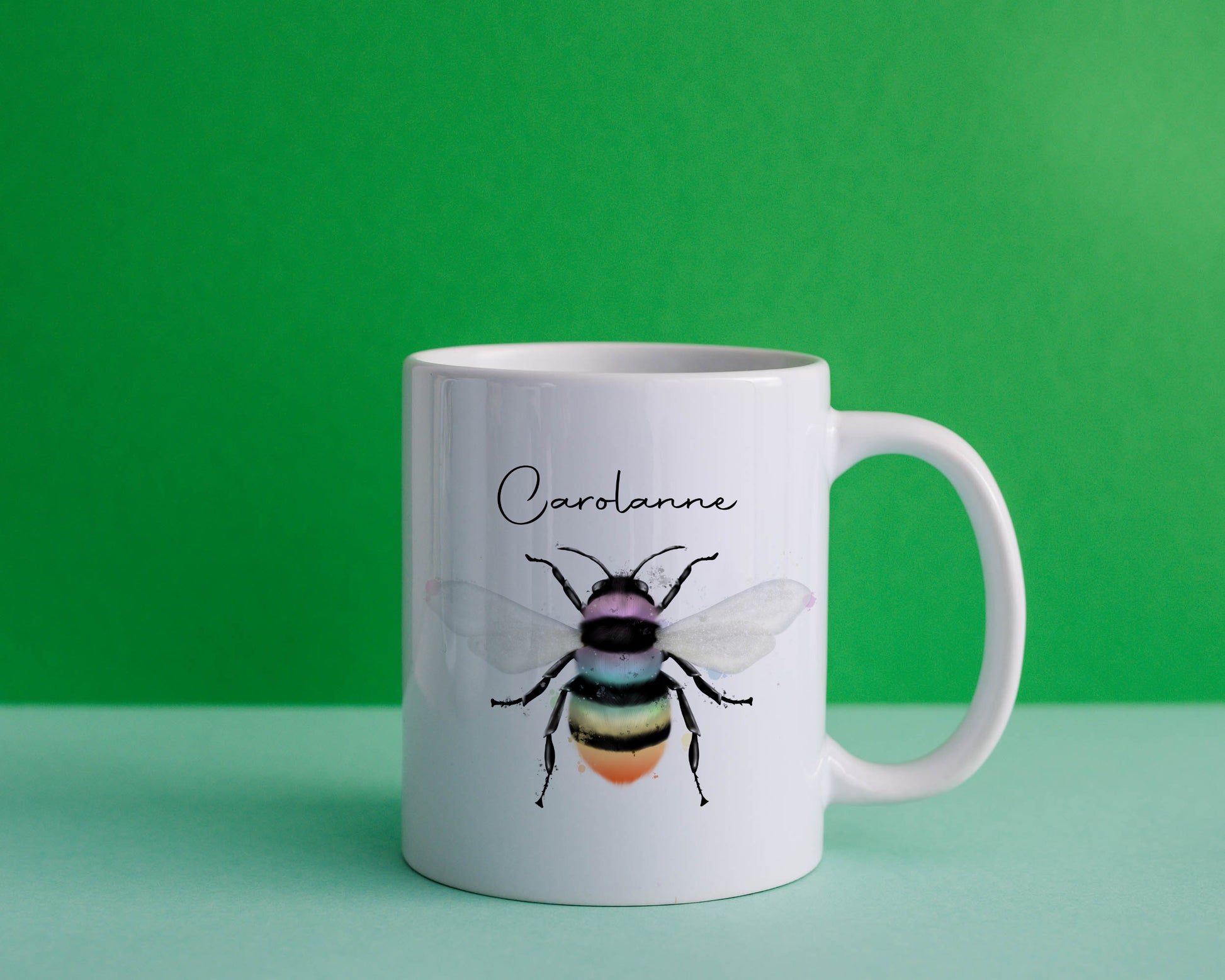 Ceramic mug with the design of a rainbow coloured bumble bee and can be personalised