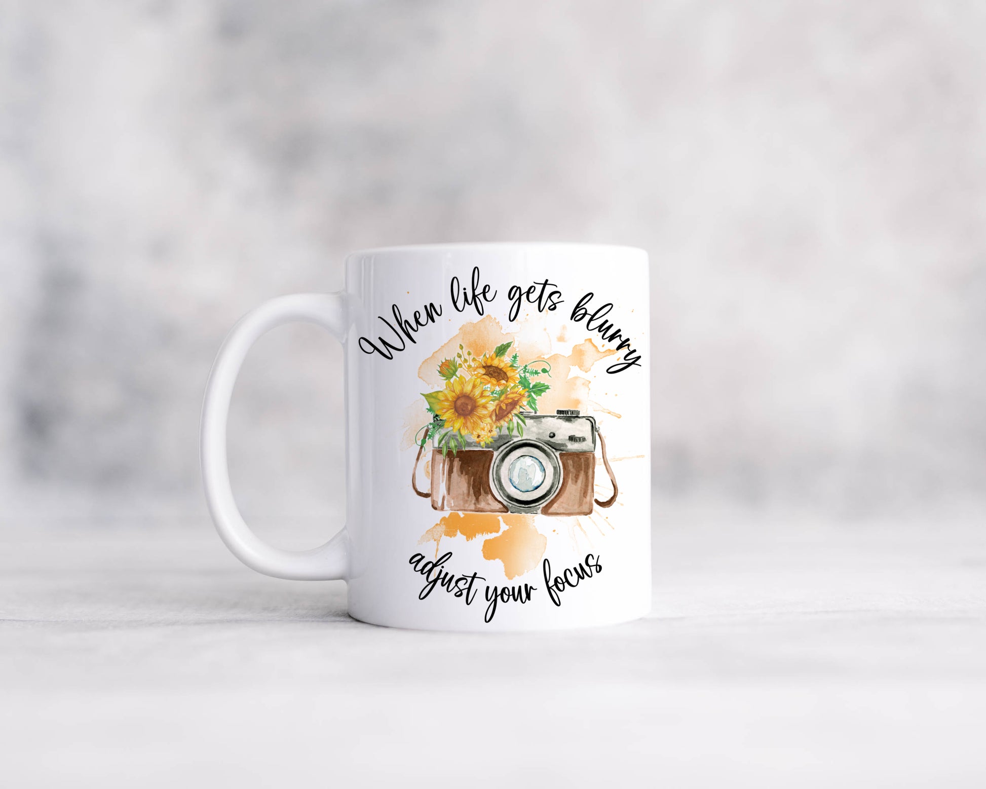 Retro camera design with sunflowers on an orange watercolour splash with the text 'When life gets blurry, adjust your focus'