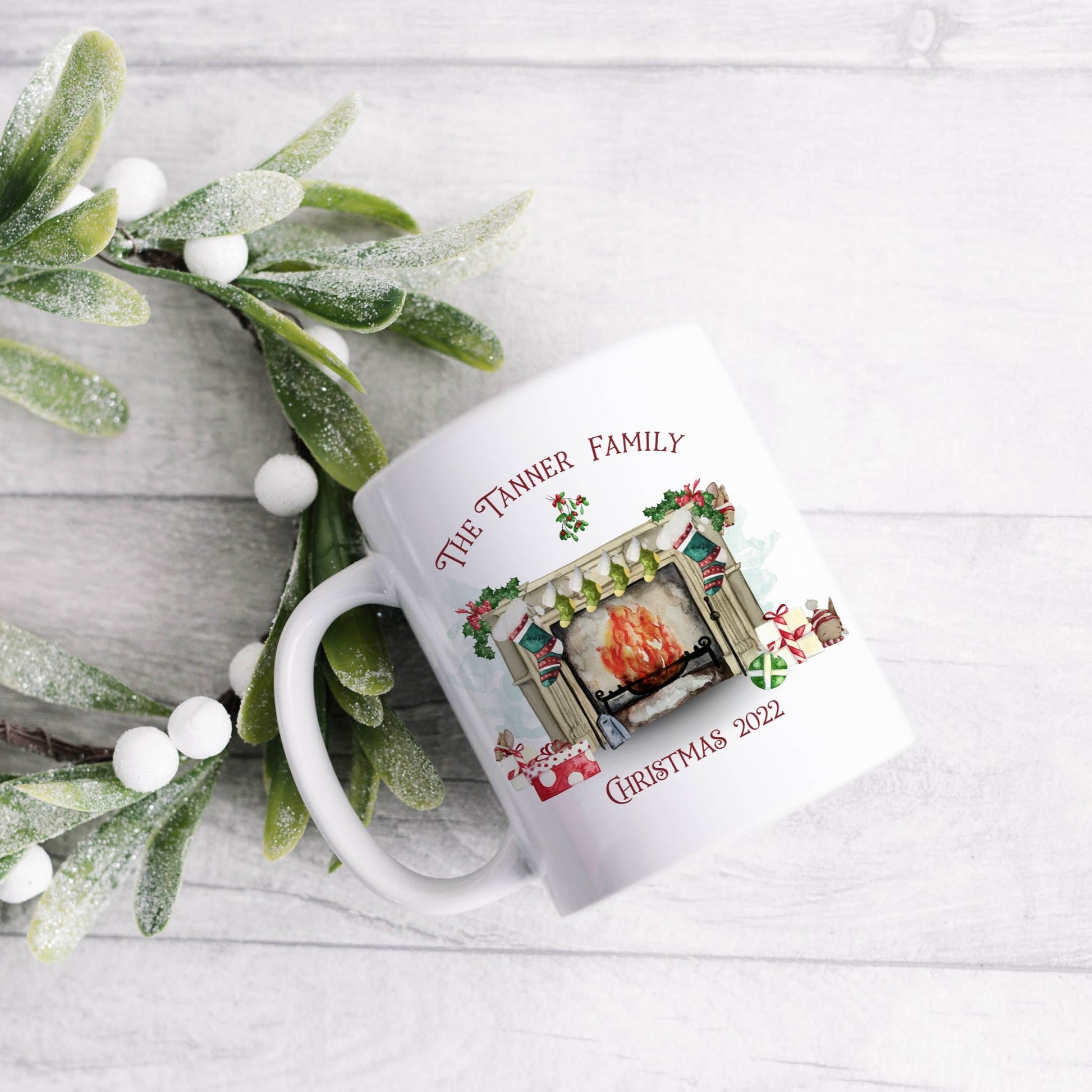 Ceramic mug featuring a traditional fireplace, green and red stockings, cute mice and wrapped gifts with personalised text